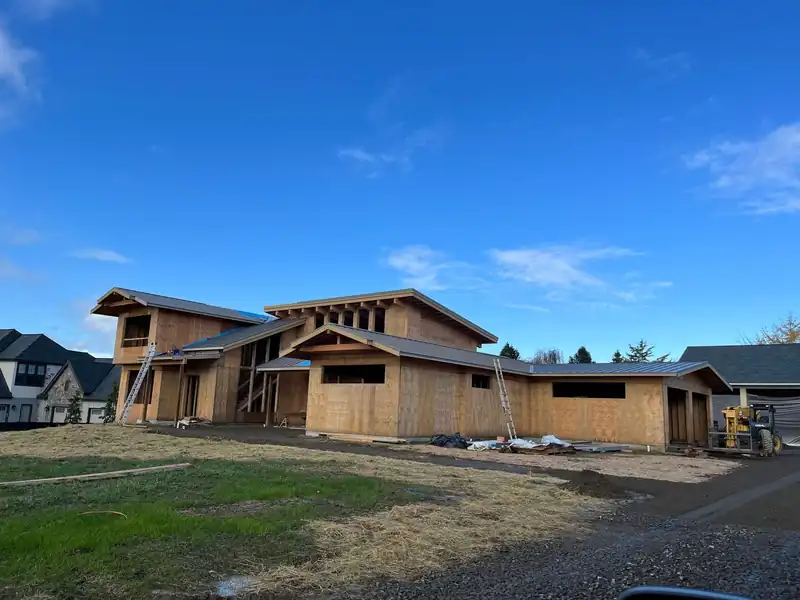 Timber-frame buildings under construction with standing-seam metal roofs