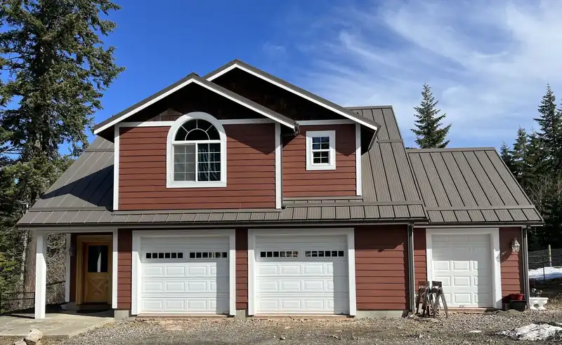 Red and white two-storey house with a dark standing-seam roof over a three-bay garage